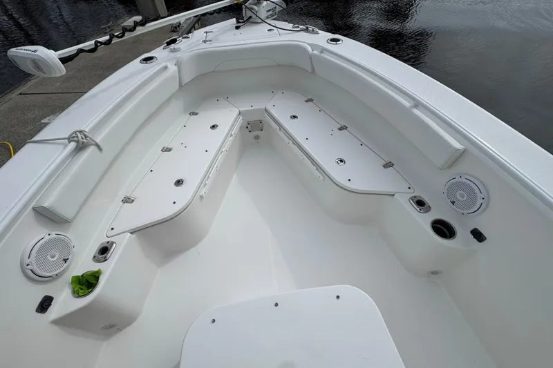 Slide: The Image of 2019 Edgewater 230CC boat interior with seating and table, docked by calm water. - 30
