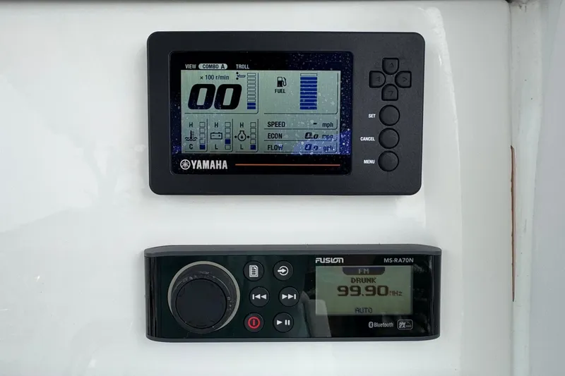 Slide: The Image of 2019 Edgewater 230CC boat cockpit with steering wheel and control panel by the water. - 42