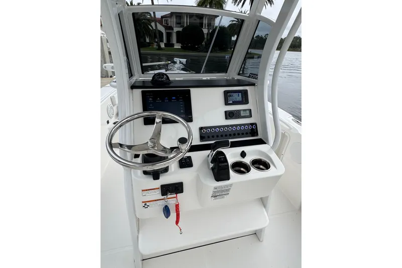 Slide: The Image of Edgewater 230CC 2019 boat console with steering wheel, controls, and electronic displays. - 48