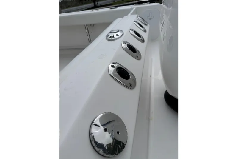 Slide: The Image of 2019 Edgewater 230CC boat roof with speakers and storage net, palm trees in background. - 52