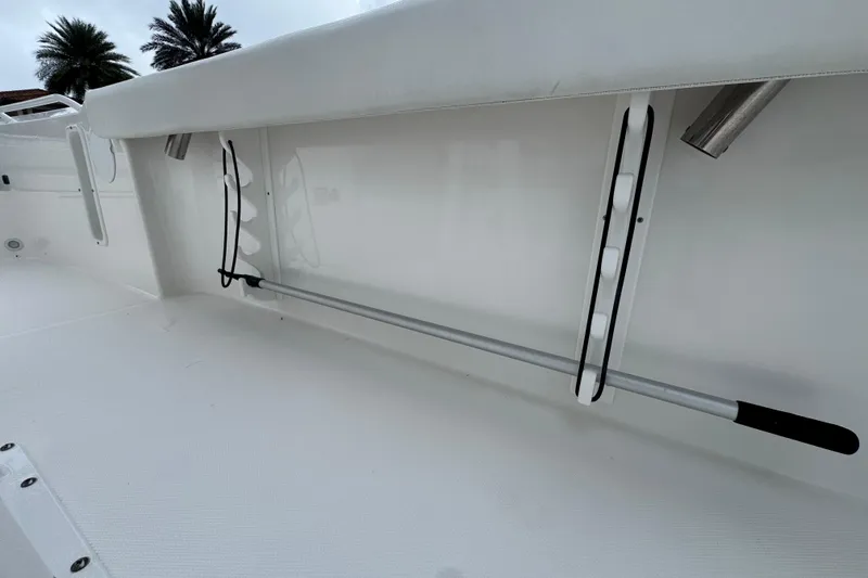Slide: The Image of 2019 Edgewater 230CC boat interior with rod holder and white seating. - 55
