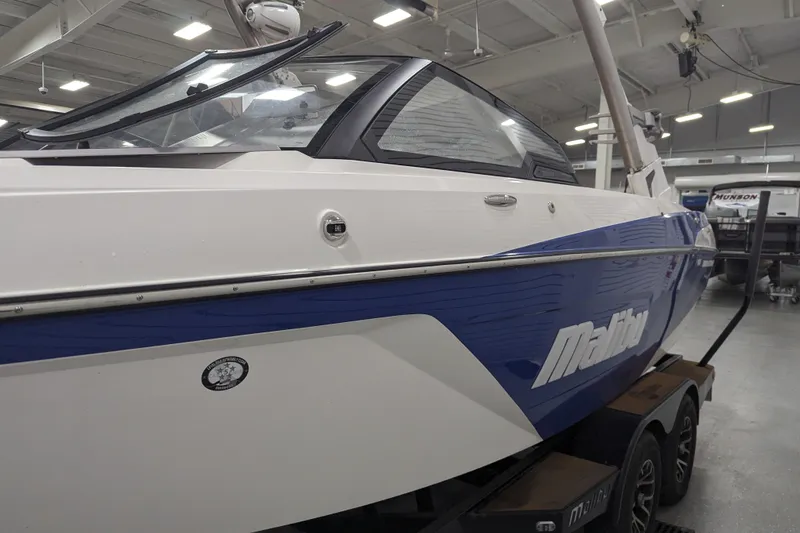 Slide: The Image of 2021 Malibu Wakesetter 22 LSV boat in showroom, blue and white exterior. - 14