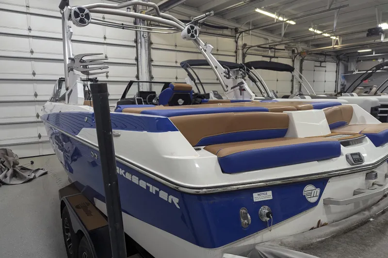 Slide: The Image of 2021 Malibu Wakesetter 22 LSV boat in a garage, featuring blue and white design. - 15