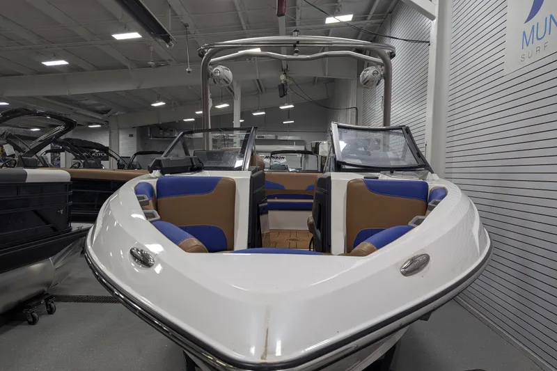 Slide: The Image of 2021 Malibu Wakesetter 22 LSV boat with blue and brown interior in showroom. - 18