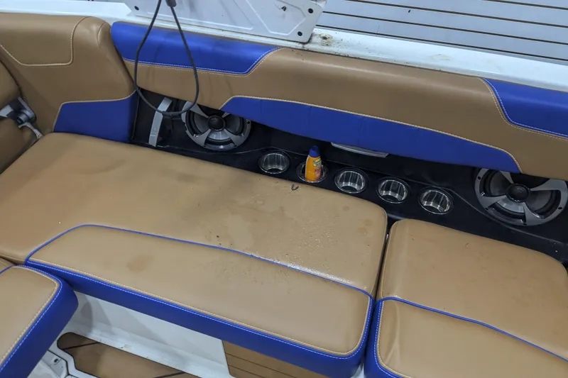 Slide: The Image of 2021 Malibu Wakesetter 22 LSV interior with tan and blue seating, cup holders, and speakers. - 25