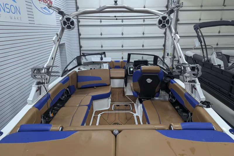 Slide: The Image of 2021 Malibu Wakesetter 22 LSV interior with tan and blue seating, in a showroom. - 31