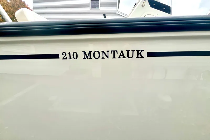 Slide: The Image of 2020 Boston Whaler 210 Montauk boat deck, featuring spacious seating and storage. - 16