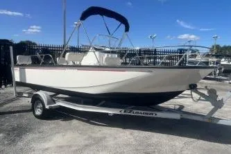 Slide: The Image of 2024 Boston Whaler 190 Montauk boat on trailer, parked outdoors under clear sky. - 3
