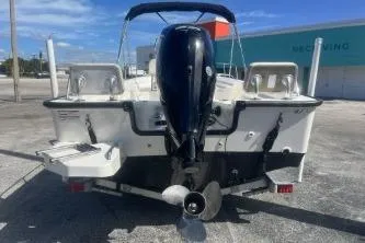 Slide: The Image of 2024 Boston Whaler 190 Montauk boat, rear view with outboard motor, parked outdoors. - 5