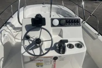 Slide: The Image of 2024 Boston Whaler 190 Montauk boat console with steering wheel and controls. - 7