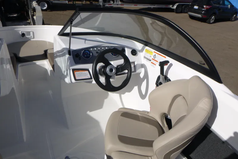 Slide: The Image of 2024 Tahoe 185 S boat interior with steering wheel and beige seating. - 12