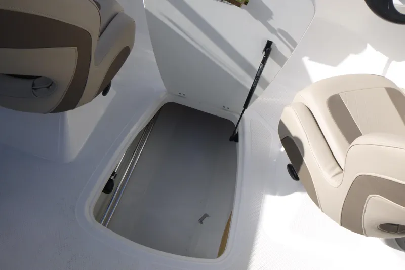 Slide: The Image of 2024 Tahoe 185 S boat interior storage compartment with beige seating. - 17