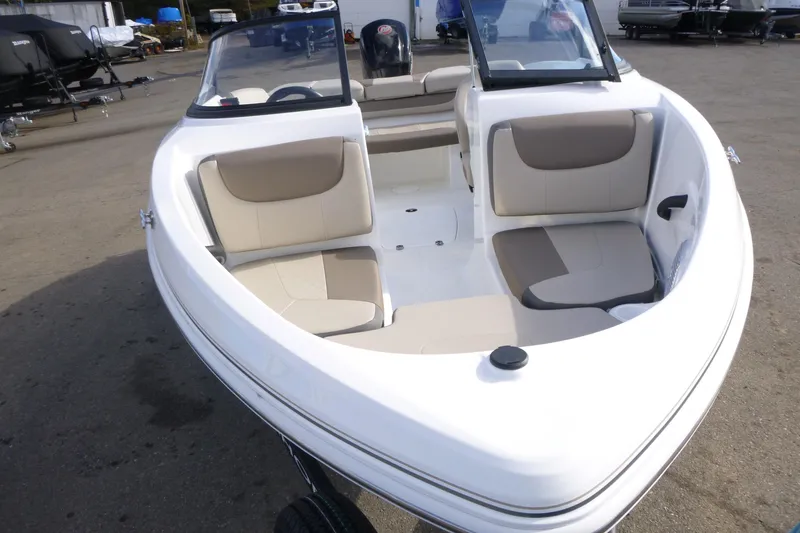 Slide: The Image of 2024 Tahoe 185 S boat with beige seating, docked outdoors. - 24