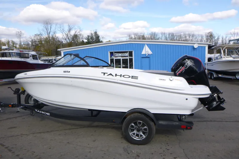 Slide: The Image of 2024 Tahoe 185 S boat on trailer outside blue showroom building. - 5