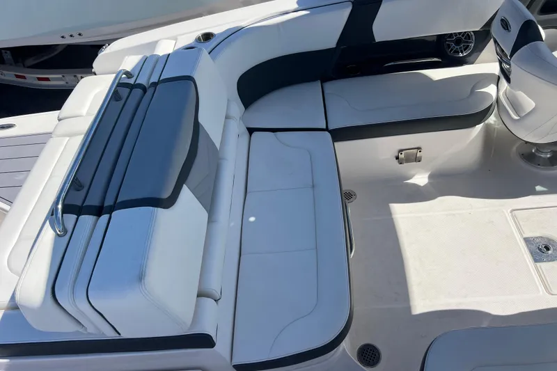 Slide: The Image of 2023 Chaparral 270 OSX boat interior with white cushioned seating and sleek design. - 10
