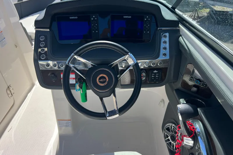 Slide: The Image of 2023 Chaparral 270 OSX boat dashboard with steering wheel and dual Simrad displays. - 14