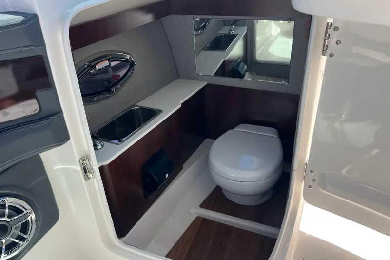 Slide: The Image of 2023 Chaparral 270 OSX boat interior bathroom with sink, toilet, and mirror. - 17