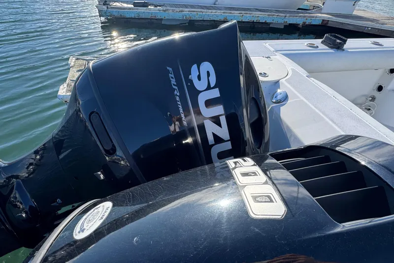 Slide: The Image of Outboard motors on a 2004 Boston Whaler 255 Conquest boat at a dock. - 10