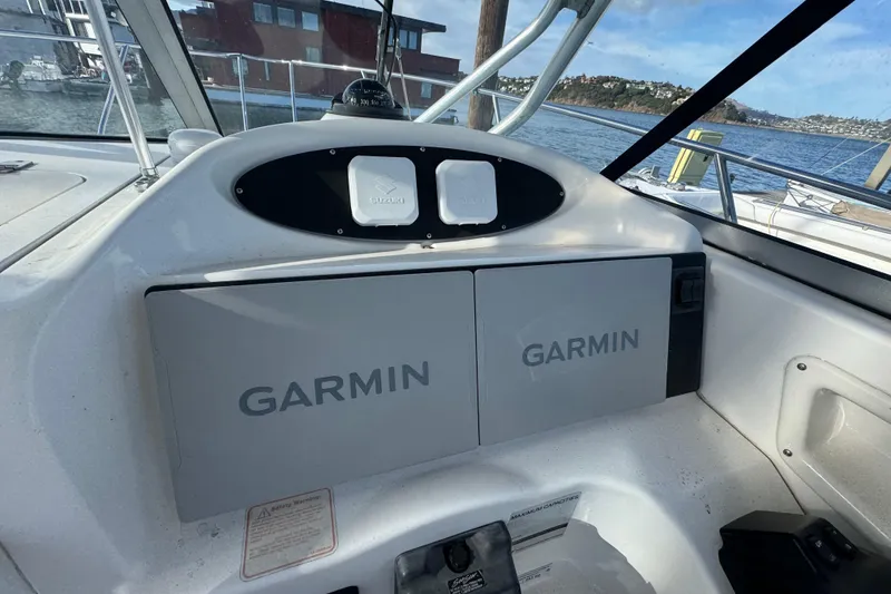 Slide: The Image of Helm of 2004 Boston Whaler 255 Conquest with Garmin navigation system, docked by the water. - 14