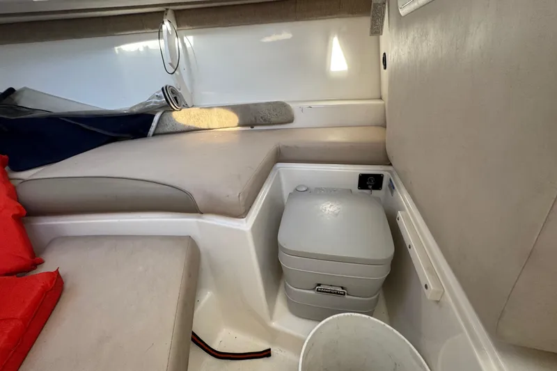 Slide: The Image of 2004 Boston Whaler 255 Conquest cabin interior with seating and portable toilet. - 17