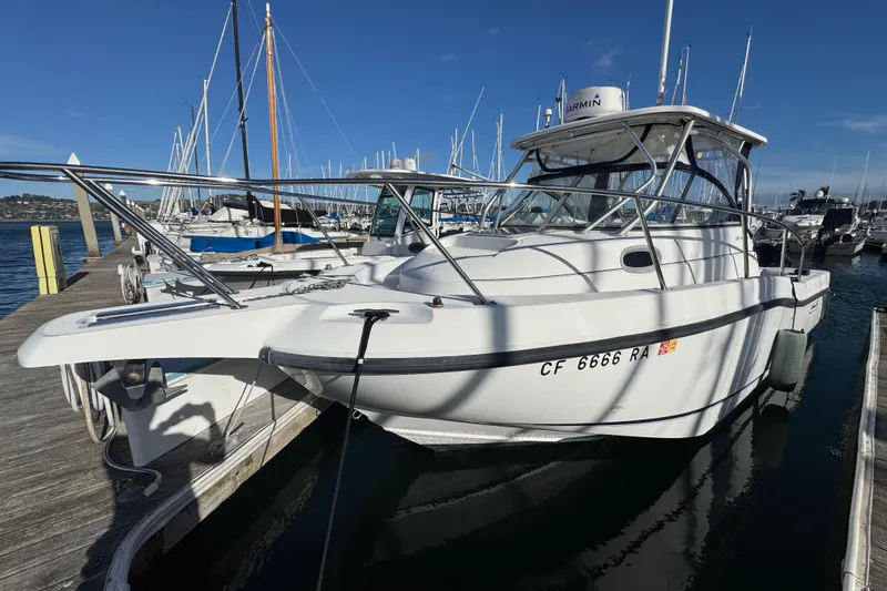 Slide: The Image of 2004 Boston Whaler 255 Conquest boat docked at marina, clear sky background. - 4