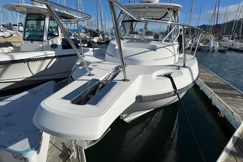 Slide: The Image of 2004 Boston Whaler 255 Conquest boat docked at marina, showcasing sleek design and sturdy build. - 5