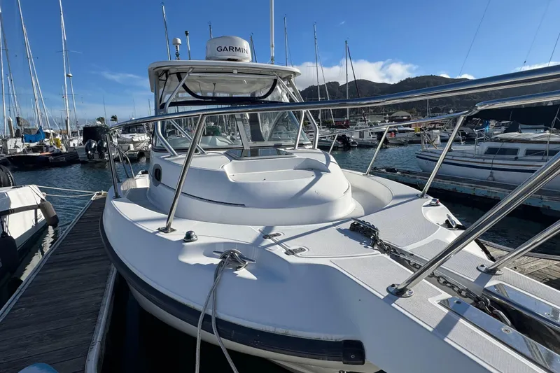 Slide: The Image of 2004 Boston Whaler 255 Conquest boat docked at marina, clear sky background. - 6