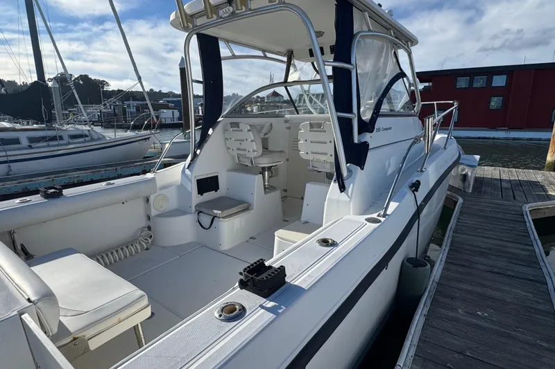 Slide: The Image of 2004 Boston Whaler 255 Conquest boat docked at marina, showcasing spacious cockpit. - 8