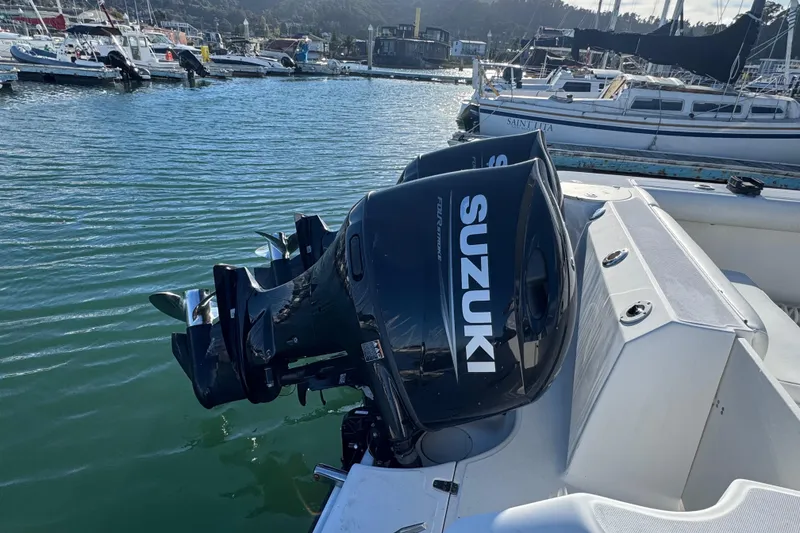 Slide: The Image of 2004 Boston Whaler 255 Conquest with Suzuki outboard engines docked in marina. - 9