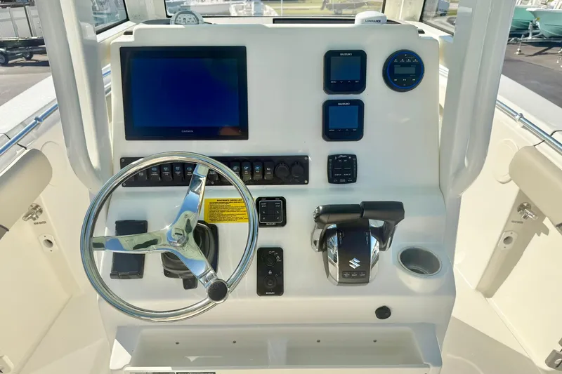 Slide: The Image of 2026 Key West 244 Center Console boat dashboard with steering wheel and electronic controls. - 3