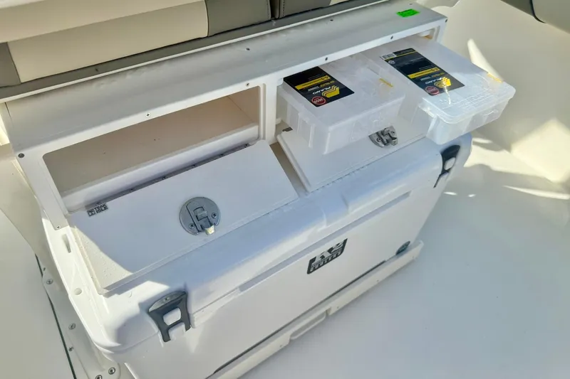 Slide: The Image of 2026 Key West 244 Center Console storage compartments with tackle boxes and cooler. - 40