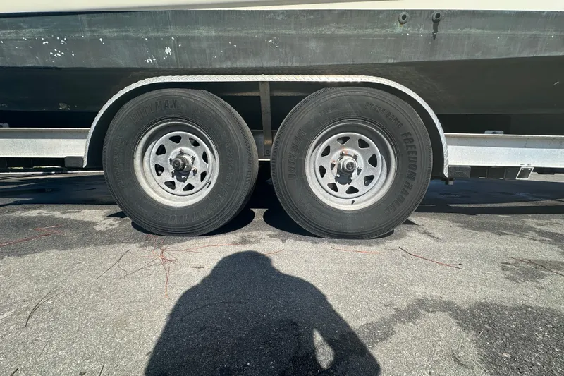 Slide: The Image of Trailer wheels of a 2009 Scarab Sport 30 boat on pavement. - 17