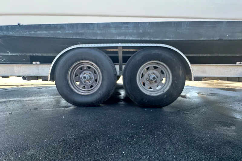 Slide: The Image of Trailer wheels of a 2009 Scarab Sport 30 boat on asphalt surface. - 18