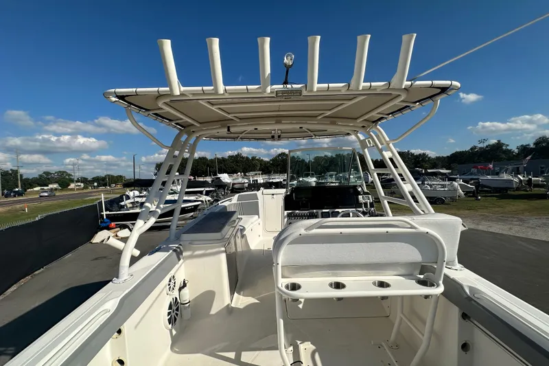Slide: The Image of 2009 Scarab Sport 30 boat with T-top and seating, docked under clear blue sky. - 23