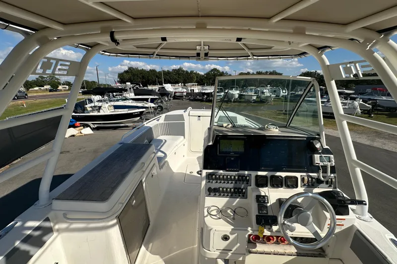Slide: The Image of 2009 Scarab Sport 30 boat interior with control panel and steering wheel, docked at marina. - 26