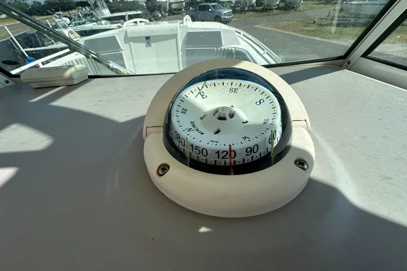 Slide: The Image of Compass on 2009 Scarab Sport 30 boat dashboard, with marina view in background. - 27