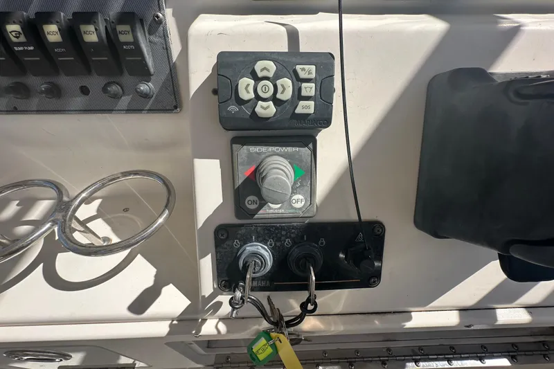 Slide: The Image of Control panel of a 2009 Scarab Sport 30 boat with switches and keys. - 31