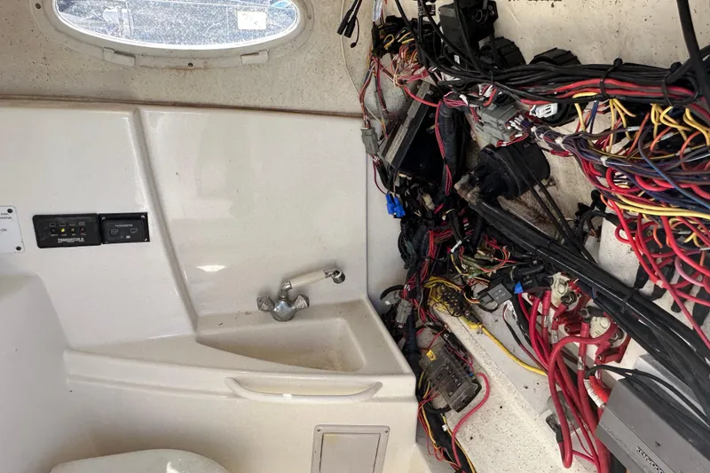 Slide: The Image of Interior of a 2009 Scarab Sport 30 boat showing wiring and a small sink. - 43