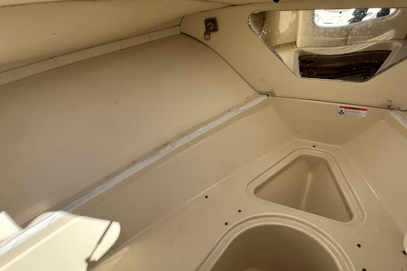 Slide: The Image of 2009 Scarab Sport 30 boat interior, featuring beige cabin space and storage compartments. - 50