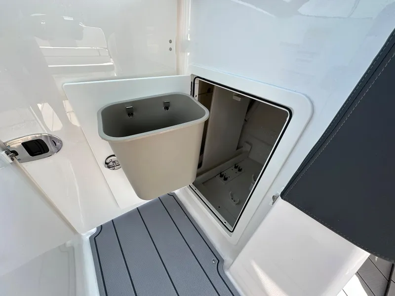 Slide: The Image of 2023 Chaparral 270 OSX boat storage compartment with integrated trash bin. - 23