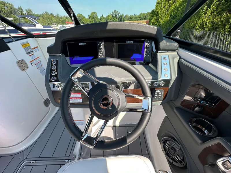 Slide: The Image of 2023 Chaparral 270 OSX boat dashboard with dual Simrad displays and modern steering wheel. - 25