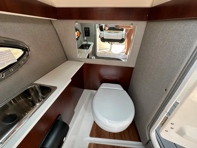 Slide: The Image of 2023 Chaparral 270 OSX boat interior bathroom with sink, toilet, and mirror. - 35