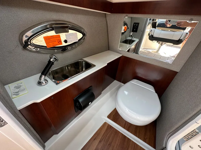 Slide: The Image of 2023 Chaparral 270 OSX boat interior bathroom with sink, toilet, and mirror. - 36