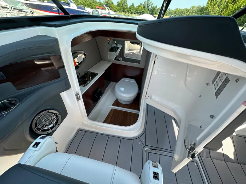 Slide: The Image of 2023 Chaparral 270 OSX boat interior with cabin and toilet, featuring modern design and amenities. - 37