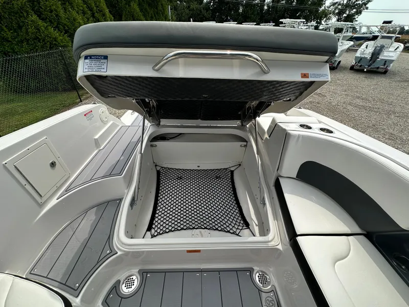 Slide: The Image of 2023 Chaparral 270 OSX boat with open storage compartment, showcasing sleek interior design. - 47