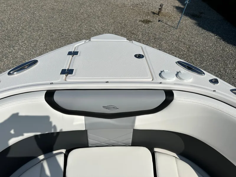 Slide: The Image of 2023 Chaparral 270 OSX boat bow with white seating and storage compartments. - 5