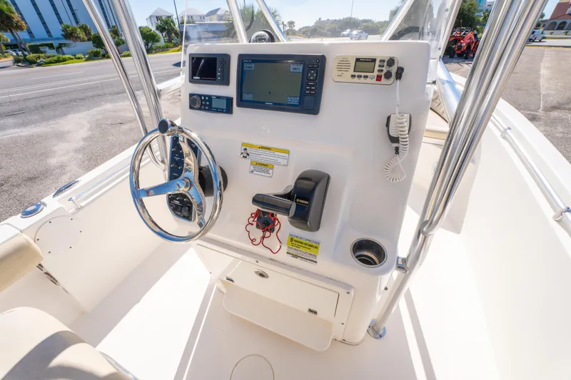 Slide: The Image of 2017 Cobia 220 Center Console boat dashboard with steering wheel and navigation equipment. - 13