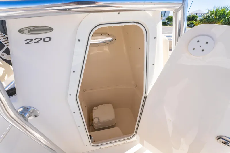 Slide: The Image of 2017 Cobia 220 Center Console boat with open storage compartment. - 24