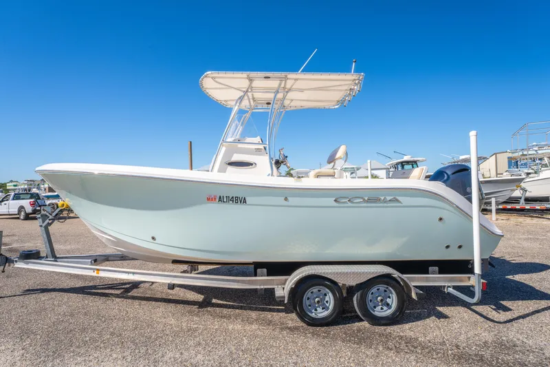 Slide: The Image of 2017 Cobia 220 Center Console boat on trailer under clear blue sky. - 7