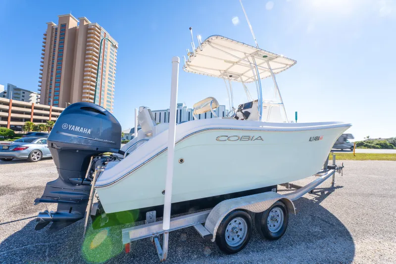 Slide: The Image of 2017 Cobia 220 Center Console boat on trailer with Yamaha engine, cityscape background. - 9